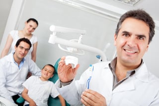 Dentist holding a toothbrush and showing how to use it properly influencer dental.jpeg