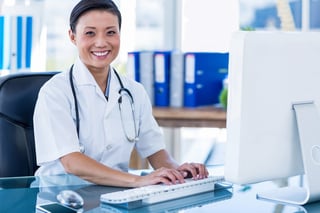 Happy doctor using her computer to stay in touch with patients medical marketing solutions.jpeg