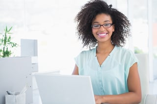 Happy hipster businesswoman working on laptop in her office.jpeg