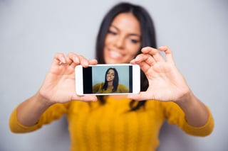 Happy woman influencer making video photo selfie on mobile. Focus on smartphone.jpeg Happy woman influencer making video photo selfie on mobile. Focus on smartphone.jpeg
