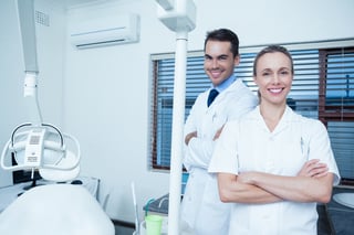 Portrait of smiling male and female dentists blogging medical marketing solutions.jpeg